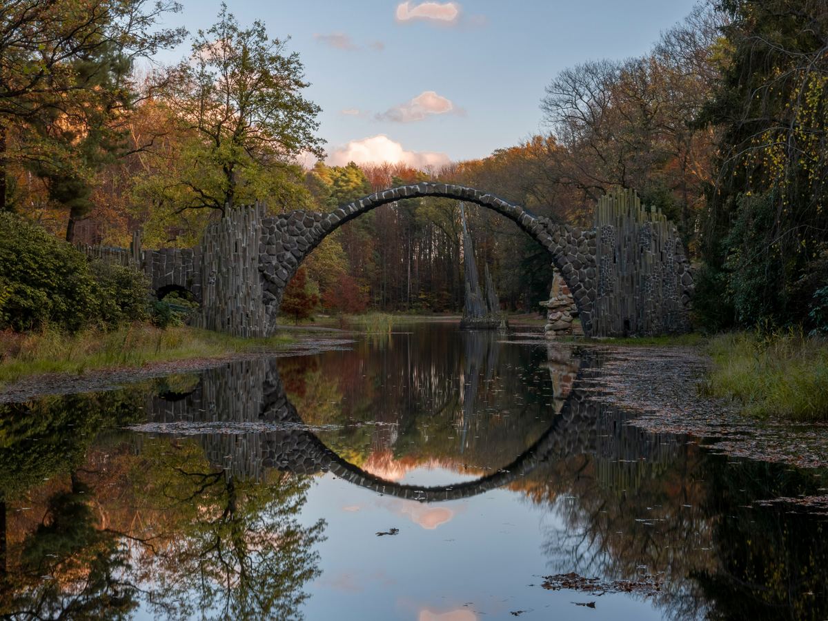 We'll cross the Rakotzbrücke in Saxony's Kromlau park, the arch whose reflection makes a perfect stone circle.
